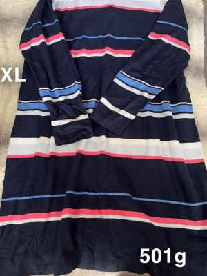 Randig långärmad klänning XL - Mysig långärmad klänning i marinblått med breda ränder i vitt, blått och rött. Klänningen har en avslappnad passform och är perfekt för dig som gillar en enkel men färgglad stil. 🌸 Några fläckar och noppor. Storlek XL