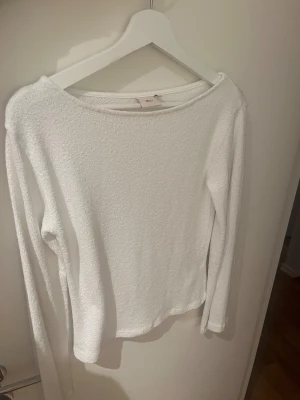 Vit långärmad tröja från nelly - En stilren vit långärmad tröja från nelly med rundad hals och mjukt, strukturerat material. Perfekt för dig som gillar enkel och clean look. Passar dig som vill ha en basic tröja med skön passform och diskret vibe.