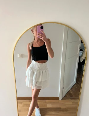 Vit volangkjol  - Supersöt vit kortkjol med smockad midja & dubbla volanger. Säljer då den tyvärr inte kommer till användning längre. Är ifrån Chelsea & i storlek XS🤍