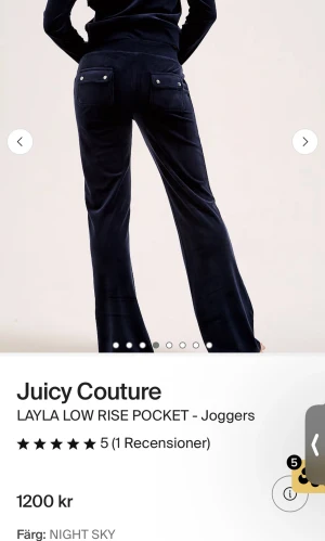  Juicy  - Säljer ett par marinblå mjukisbyxor med snörning i midjan och fickor bak med knappdetaljer. Byxorna har en relaxed passform och är perfekta för chill dagar. Materialet känns mjukt och bekvämt, och modellen är lågmidjad för en avslappnad vibe.