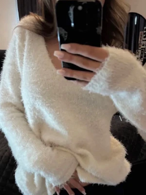 Fluffig vit v-ringad tröja Gina Tricot - Supermjuk och fluffig vit stickad tröja från Gina Tricot med v-ringning. Långärmad modell med relaxed fit och mysig känsla, perfekt för kyliga dagar. Enkel att styla med jeans eller kjol för en chill look.