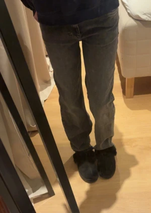 Grå raka jeans med vintagekänsla - Säljer ett par grå jeans med rak passform och klassisk femficksdesign. Jeansen har en snygg tvättad look och midja som sitter perfekt. Materialet är robust denim som ger en avslappnad vibe. Perfekta till sneakers eller boots för en chill stil. Storlek 27/32