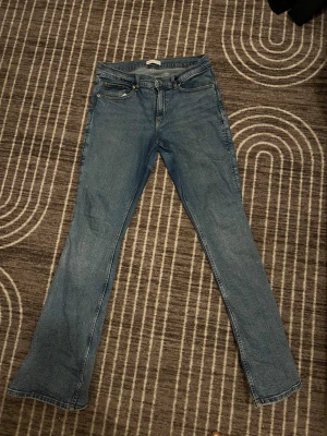 Blå bootcut jeans från gina är använda - Snygga blå jeans från Levi's med klassisk femficksdesign och bootcut-ben. Jeansen har normal passform och är tillverkade i slitstarkt denimtyg. Perfekt för dig som gillar retrovibbar och vill ha ett par jeans med lite extra sväng i benen.