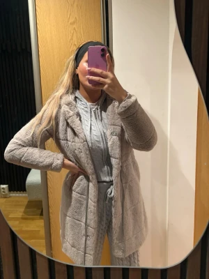 Beige teddyjacka med huva - Säljer en supermjuk och fluffig teddyjacka i beige färg. Jackan har huva, långa ärmar och praktiska fickor på sidorna. Perfekt för dig som gillar chill och cozy vibes under höst och vinter. Jackan har en loose passform och är tillverkad i fleece-material. 