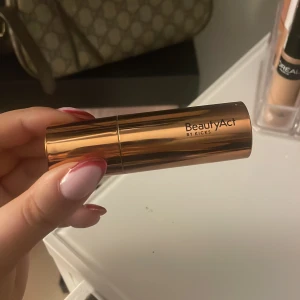 BeautyAct bronzer stick Mañana - Krämig bronzer i stickformat från BeautyAct by Kicks i nyansen Mañana. Kommer i en snygg, metallisk kopparfärgad hylsa. Perfekt för att skapa en solkysst look och enkel att applicera direkt på huden.