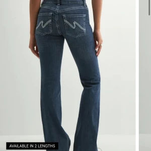 Blå bootcut jeans från Nelly, stl 36 - Snygga blå jeans från Nelly i bootcut-modell med klassisk femficksdesign och vita sömmar på bakfickorna. Jeansen har normal midja och är tillverkade i mjukt denim-material som sitter skönt. Perfekta för dig som gillar en tidlös look med lite extra edge.