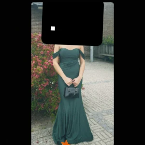 Balklänning - En mörkgrön balklänning som är offshoulder med padding i bysten. Tajt ⬆️, sedan blir den mer flowig nertill. Väldigt bekväm med stretch, strlk 36/S men stretchig somsagt. För referens så är jag 168cm- 62 kg.