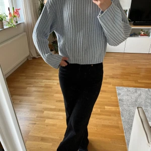 Ljusblå ribbad tröja från H&M Divided - Säljer en ljusblå ribbad tröja från H&M Divided i storlek M. Tröjan har en högre hals som jag vikt ner på bilderna, långärmade och loose passform. Materialet är väldigt mjukt och bekvämt och stickat, perfekt för att hålla dig varm under kyliga dagar. Snygg att styla med både jeans och kjol. Den är lite cropped i modellen och knappt använd 