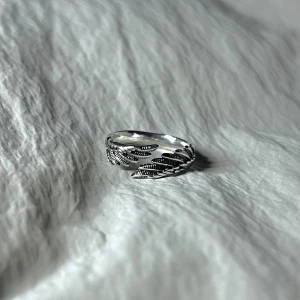 Aéris Merge - Två vingar sammanflätas i ett minimalistiskt uttryck.