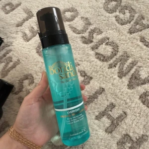 Bondi Sands Gradual Tan Face Mist - Fräsch ansiktsmist från Bondi Sands i en turkos plastflaska med svart pump. Ger gradvis solbrun ton och återfuktar huden med en lätt formula. Perfekt för dig som vill ha en naturlig glow och enkel applicering.