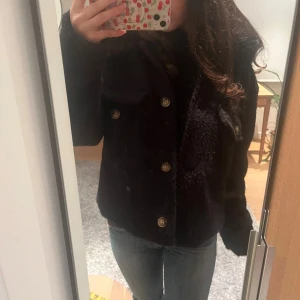 Svart teddyjacka med stora knappar - Mysig svart teddyjacka med stora guldiga knappar framtill och två bröstfickor. Jackan har långa armar och passar bra nu till kallare väder! ❄️Kan absolut sänka priset vid snabb handel. 🩷Nypris 999kr
