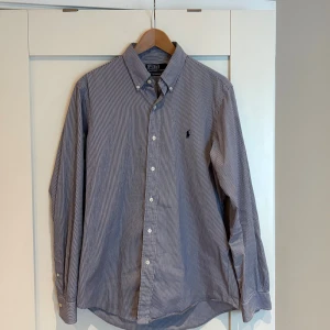 Polo Ralph Lauren Skjorta - Säljer en blå vit randig skjorta från Polo Ralph Lauren. Storlek M och i riktigt bra skick med inga defekter‼️🔛🔝. Hör av er vid frågor eller funderingar 💸✅