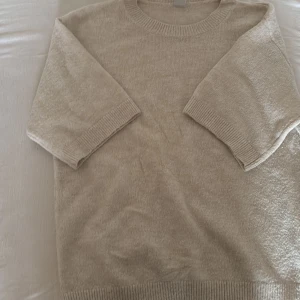 Beige stickad tröja från Lindex - Og pris: 249. Den har en fläck men om man kollar noga så syns den. Den är bara använd ett par gånger vet ej hur fläcken kom.Mysig beige stickad tröja från Lindex med rund hals och ribbade muddar vid ärmslut och nederkant. Tröjan har trekvartsärm och är perfekt för dig som gillar en enkel och clean stil. Passar dig som vill ha en neutral färg i garderoben.