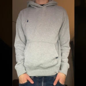 Grå hoodie från Polo Ralph Lauren - Säljer denna riktigt snygga hoodien från Ralph Lauren. Stl M men passar kanske bättre som en S. Superskick, inga defekter, endast snöret till huvan som saknas. Fråga mig gärna om mått etc ☀️