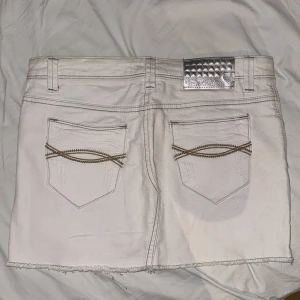 Vit jeanskjol från Girls Denim -  Vit kort jeanskjol från Girls Denim med rå kant nedtill och snygga bakfickor med dekorativa sömmar. Storleken är 158-164 men passar mig som har större än det. Pris kan diskuteras.
