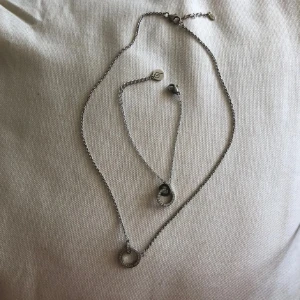 Snyggt halsband med cirkelhänge - Set med halsband och armband i äkta silver. Båda har runda berlocker med gnistrande stenar/diamanter runt hela cirkeln för en stilren och glittrig look. jätte fina men har inte kommit till användning typ nån gång (fick dom i present för många år sen).