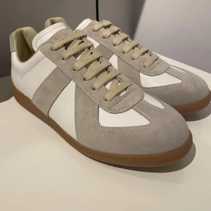 Maison Margiela GATs - Säljer dessa ursnygga Maison Margiela GATs i klassisk vit | Skick: helt nya 10/10 | Storlek 42 i | Kvitto finns, originalbox och dust- bag ingår vid köp | Hör av er för mer info/bilder - först till kvarn!