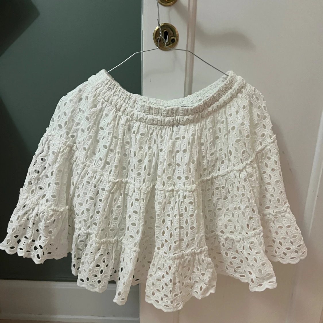 Vit kort kjol med volanger och spets