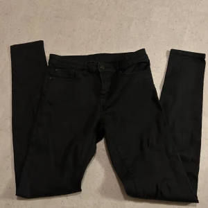 Svarta skinny jeans  - hjälper min mamma att sälja dina svarta jeans med klassisk femficksdesign och smal passform. Byxorna har bälteshällor, knapp och dragkedja fram samt raka bakfickor. Materialet är mjukt och stretchigt, vilket gör dem bekväma att bära hela dagen. priset går att diskuteras vid snabb affär!