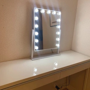 Sminkspegel - Elegant sminkspegel med 14 starka LED-lampor runt ramen, perfekt för makeup och styling. Spegeln står stadigt på ett vitt stativ och ger jämn belysning. Mycket gott skick, inga synliga repor eller skador. Modern design som passar alla sminkbord. Kostar 1000kr ny