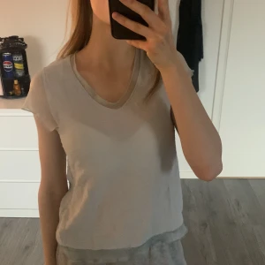 Ljusbeige t-shirt med transparenta ärmar - Säljer en ljusbeige t-shirt med v-ringad hals och korta, transparenta ärmar i ett tunt material. Perfekt för dig som gillar en enkel men unik stil. Är strl M och är därför för stor på mig. Hör av dig vid frågor💕