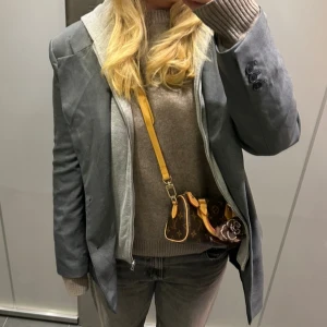 Grå oversized kavaj med knappar - Snygg grå kavaj i oversized modell med insydd hoodie. Snygg till jeans eller till yoga pants för att lyfta en outfit. Använd Max 5 gånger och nypris 500  passar en L-M 