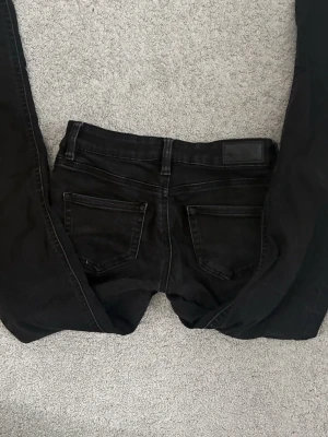 Svarta lowaist bootcut jeans  - Säljer ett par svarta lowaist bootcut jeans från Vero Moda. 