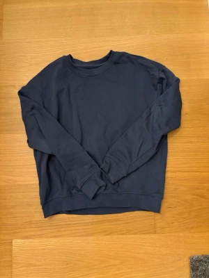 Mörkblå sweatshirt från 157, XS - Mjuk och enkel mörkblå sweatshirt från Lager 157 i storlek XS. Tröjan har rund hals, ribbade muddar vid ärmslut och nederkant samt långärmad design. Perfekt för chill dagar och passar till jeans eller mjukisbyxor. 69% Bomull, 31% Polyester.
