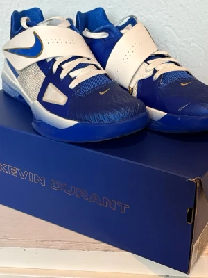 Nike Zoom KD IV Real MVP - Basketskor - Säljer ett par Nike Kevin Durant sneakers i blått och vitt med guldiga detaljer. Skorna har snörning, bred kardborreband över vristen och meshpaneler på sidorna.      Väldigt sparsamt använda basketskor, använda i ca 2 träningar och en match.