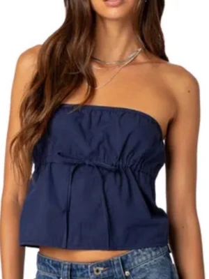 Mörkblå bandeau topp från Edikted - Säljer en mörkblå bandeau topp från Edited. Toppen är axelbandslös och har en söt knyt-detalj framtill. Tillverkad i ett mjukt bomullsmaterial som känns skönt mot huden. Perfekt till sommaren och enkel att styla med jeans eller kjol.