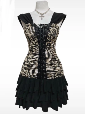 Leopardmönstrad kort klänning med korsettsnörning - Säljer en edgy kort klänning med leopardmönstrad överdel och svart volangkjol. Klänningen har korsettöverdel som går att justera. Älskar denna klänningen säljer bara eftersom att den blivit för stor 💔