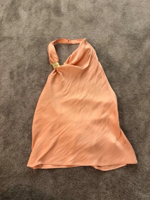 Rosa halterneck med guld från Zara - Jättefin rosa halterneck topp från Zara med guld detalj och supersnygg rygg. Tröjan är helt oanvänd då den inte kom till användning, i strl M men passar även S💞💞