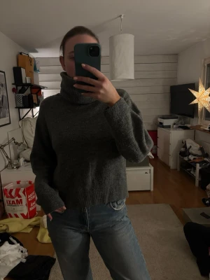 Grå polotröja från H&M XS - Mysig grå polotröja från H&M i stickat material. Tröjan har en hög, ribbad polokrage och långa ärmar med avslappnad passform. Perfekt för lager-på-lager och chill dagar. Snygg till både jeans och kjol.