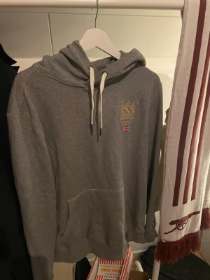 Morris hoodie grå | L | Klassisk & stilren - Säljer en grå hoodie från Morris i storlek L. Klassisk och stilren modell med Morris-logga och diskret brodyr framtill 🇬🇧  ✔️ Mycket bra skick ✔️ Inga fläckar, hål eller defekter ✔️ Mjuk och bekväm – perfekt till vardags ✔️ Rök- och djurfritt hem  Passar lika bra till jeans som chinos. Nypris var betydligt högre.  📦 Skickas snabbt 💬 Hör av dig vid frågor eller om du vill ha fler bilder