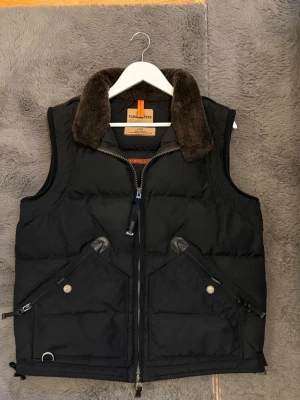 Parajumper Kobuk väst med päls  - Säljer nu en mycket sällsynt parajumper väst i mycket bra skick. Denna väst är mycket eftertraktad eftersom den tyvärr inte produceras längre. Västen har mycket olika fickor både på utsidan och insida. Finns inga fläckar eller några andra konstigheter på västen, mycket bra skick! Priset kan diskuteras så hör gärna av dig vid intresse. OBS Storlek är XL men sitter bra på mig som bär L.!!