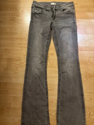 Grå bootcut jeans från Gina Tricot - Säljer ett par grå jeans från Gina Tricot med bootcut-modell. Jeansen snygga fickor. Materialet är jeans och färgen är grå. Använda 1 gång