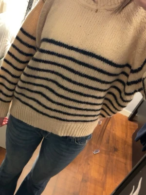 Randig stickad tröja från Cotton Candy - Beige stickad tröja från Cotton Candy i storlek M. Köpt på second hand och har bara använt 1 gång då den är lite stickig och är känslig för det. Inga defekter. 