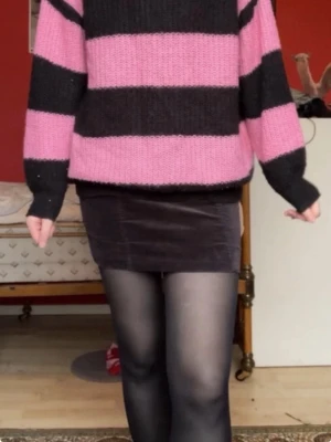 Randig stickad tröja i rosa och svart - Oversized stickad tröja. Synligt använd. Vet inte om det är svart eller mörkblått