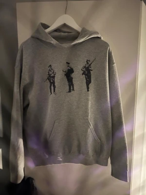 Grå hoodie  - Säljer denna grå hoodie med soldater på! Storlek S-M! Skicket är väldigt bra använd fåtal gånger. Pris 499! Går att diskutera. Var inte rädd att höra av dig vid frågor!💥✅