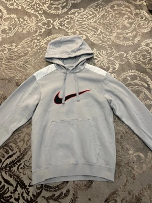 Grå vit Nike hoodie. - Säljer denna snygga grå vita Nike hoodie. Använd i en vinter, eftersom att jag har vuxit ur den. Skicka 8/10. Perfekt hoodie för vintern. Org storlek är XS fast den har krymp lite till XXS
