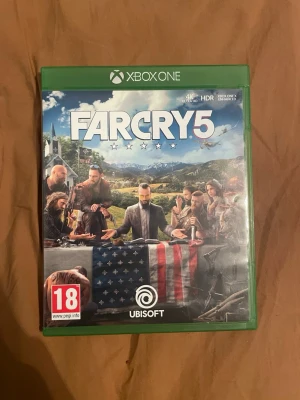 Far Cry 5 Xbox One - Far Cry 5 till Xbox One i fint skick, komplett med fodral och skiva. Upplev actionfyllda äventyr i Hope County, Montana. Stöd för 4K Ultra HD och HDR. Skivan ser ut att vara i bra skick utan synliga repor.