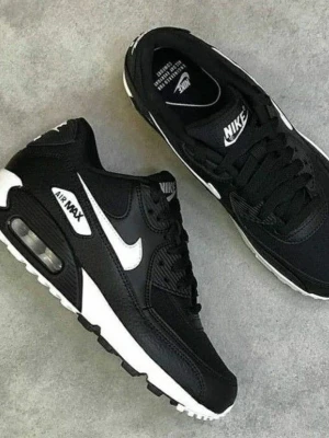 Nike Air Max 90 svart/vit sneakers - Säljer ett par klassiska Nike Air Max 90 sneakers i svart och vitt. Skorna har en chunky sula med synlig Air-enhet, vit swoosh på sidan och detaljer i både mesh och skinn. Perfekta för dig som vill ha en ikonisk och stilren look.