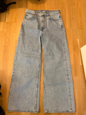 Weekday jeans W30, L32 - Ett par ljusblå jeans med vida ben och hög midja. Jeansen har klassiska detaljer som fickor fram och bak samt bälteshällor. Från weekday W30 L32