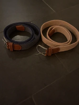 Flätade bälten - Säljer två flätade bälten ett bieget och sen ett blå vitt randigt aldrig använda.riktigt snygga bälten till bra pris😁