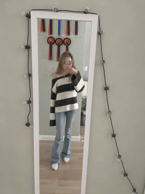Randig stickad tröja från Gina Tricot - Säljer en oversized stickad tröja från Gina Tricot med breda bruna och vita ränder. Tröjan har lång ärm, offshoulder-passform och är supermjuk och mysig. Perfekt för att slänga på sig till jeans eller leggings.