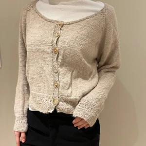 Beige Knitted Cardigan - Cozy & Stylish - A lovely beige knitted cardigan, perfect for adding warmth and style to any outfit. This cardigan features a button-up front and a soft texture, ideal for everyday wear or layering. In excellent condition, it's ready to become a staple in your wardrobe. International shipping is available, feel free to ask any questions.  beige cardigan, knitted, button-up, cozy, stylish, soft texture, everyday wear, versatile