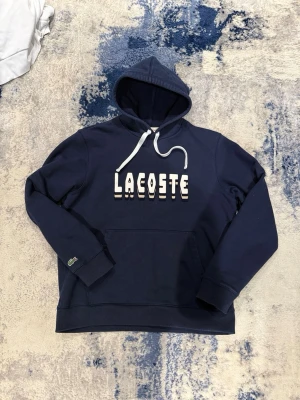 Blå Lacoste Hoodie - Säljer en riktigt fet Lacoste hoodie i storlek L men passar även M. Pris kan diskuteras vid snabb affär!