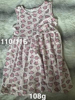 Söt kortärmad klänning med vattenmelonmönster - Supergullig ärmlös klänning i ljusrosa och vitt med tryck av små vattenmeloner över hela tyget. Klänningen har en rund halsringning och ett lätt utställt kjolparti. Perfekt för varma dagar och somriga äventyr!🌸 Fint använt skick. Storlek 110/116