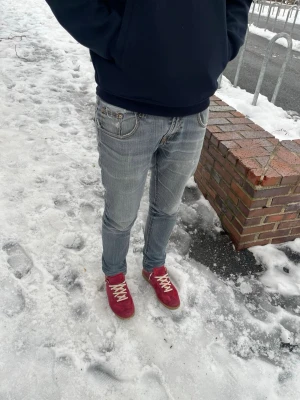 Ljusblå skinny jeans från Nudie - Modellen är 180, 75kg‼️W32, L32. Säljer ett par ljusblå skinny jeans från Nudie med klassisk femficksdesign och snygga slitningar. Jeansen har låg midja och är tillverkade i mjukt denimtyg som sitter tight hela vägen ner. Perfekta för dig som gillar en smal siluett och vill ha ett par riktigt schyssta jeans. Modell dry japan denim‼️