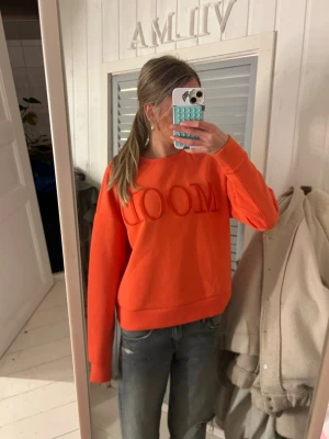 Orange sweatshirt från VILA med brodyr - Säljer en orange sweatshirt från VILA i storlek S med broderad texten 'MOOD' framtill. Tröjan har rund halsringning och långa ärmar. Tillverkad i mjuk bomullsblandning, perfekt för en chill och färgstark look.